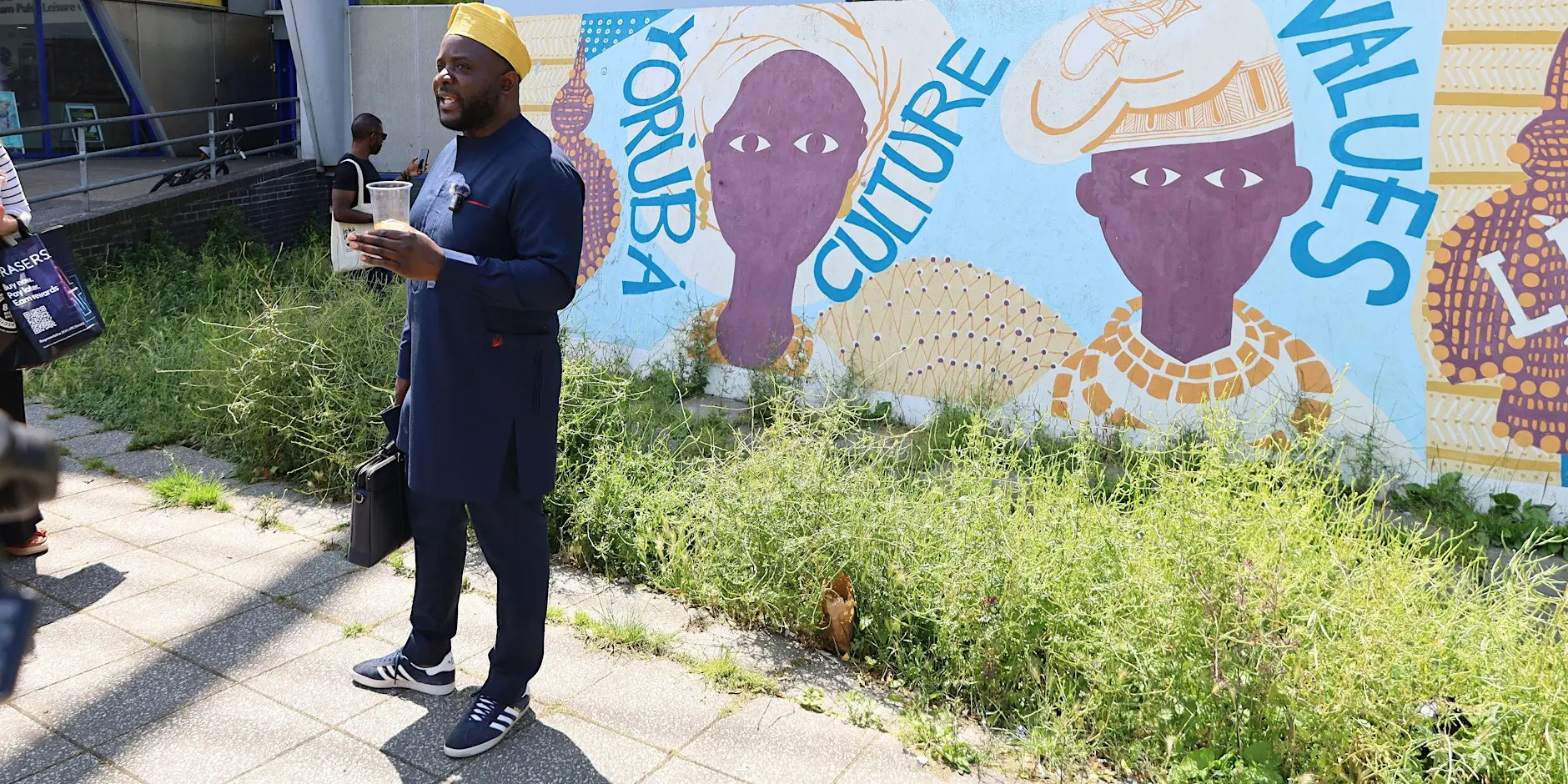 Je Ka Jeun founder in front of a Yoruba culture mural in Peckham